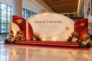 Sunway University graduation celebration with a layered graduation photo wall, safe low two-step group-photo platform and restrained graduation cap motifs