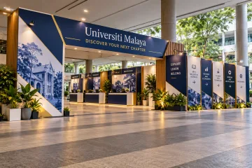 Universiti Malaya university open day with a wide university open-day walk-through welcome portal, registration counters and readable faculty wayfinding panels